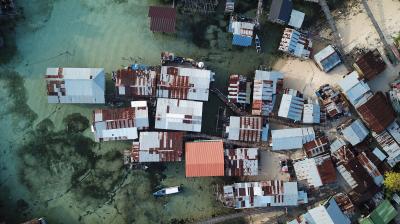 An aerial view of a group of shacks in the water.