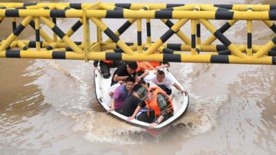 A group of people riding a boat in a flooded area.