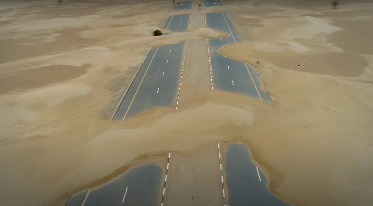 an aerial view of a road in the desert.
