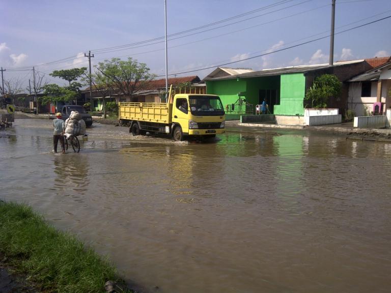 A truck driving down a flooded street.