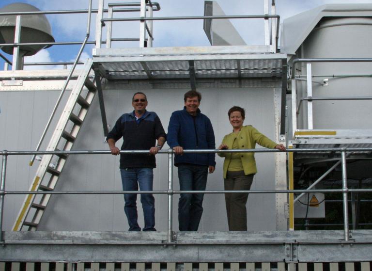 Three people standing on a railing.Sue Barrell autosonde at the Lord Howe Island BOM station.jpg