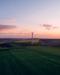 Wind turbines in a rural landscape at sunset.